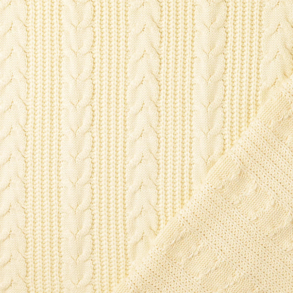 Weicher cremefarbener Strickstoff mit klassischem Zopfmuster