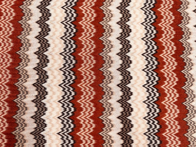Zackenstrick Stoff in Rost, Beige und Ecru, 100% Polyester, 140 cm breit, gemusterter Strickstoff für Pullover und Cardigans.
