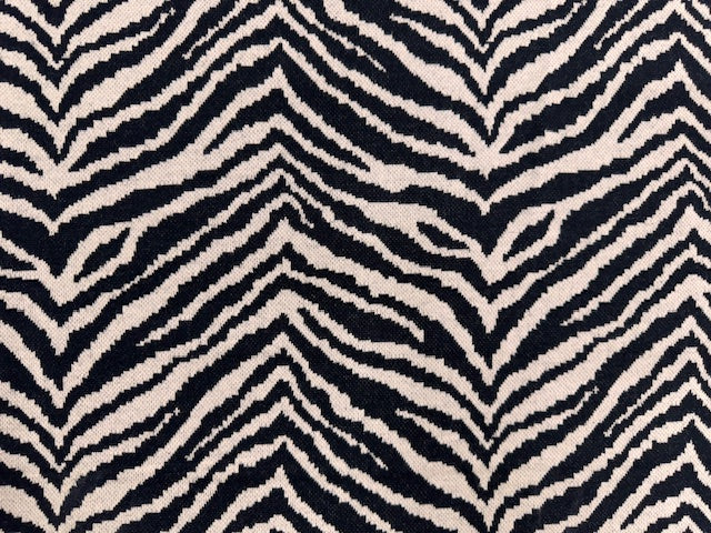 Sandfarbener Jacquard-Strick mit Zebramuster, weich angeraut und aufgerollt dargestellt