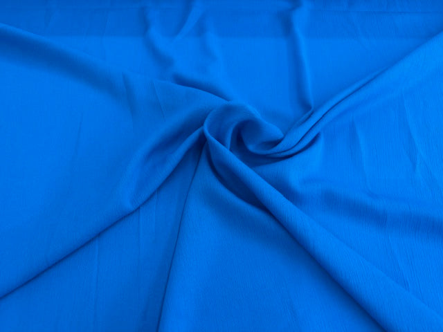 Blauer Crinkle Stoff aus 100 % Viskose mit weicher Struktur als Meterware