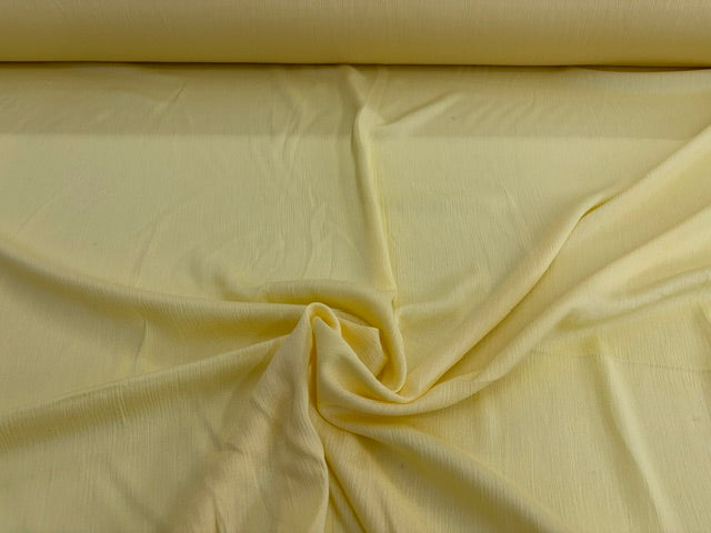 Gelber Crinkle Stoff aus 100 % Viskose mit weicher Struktur als Meterware